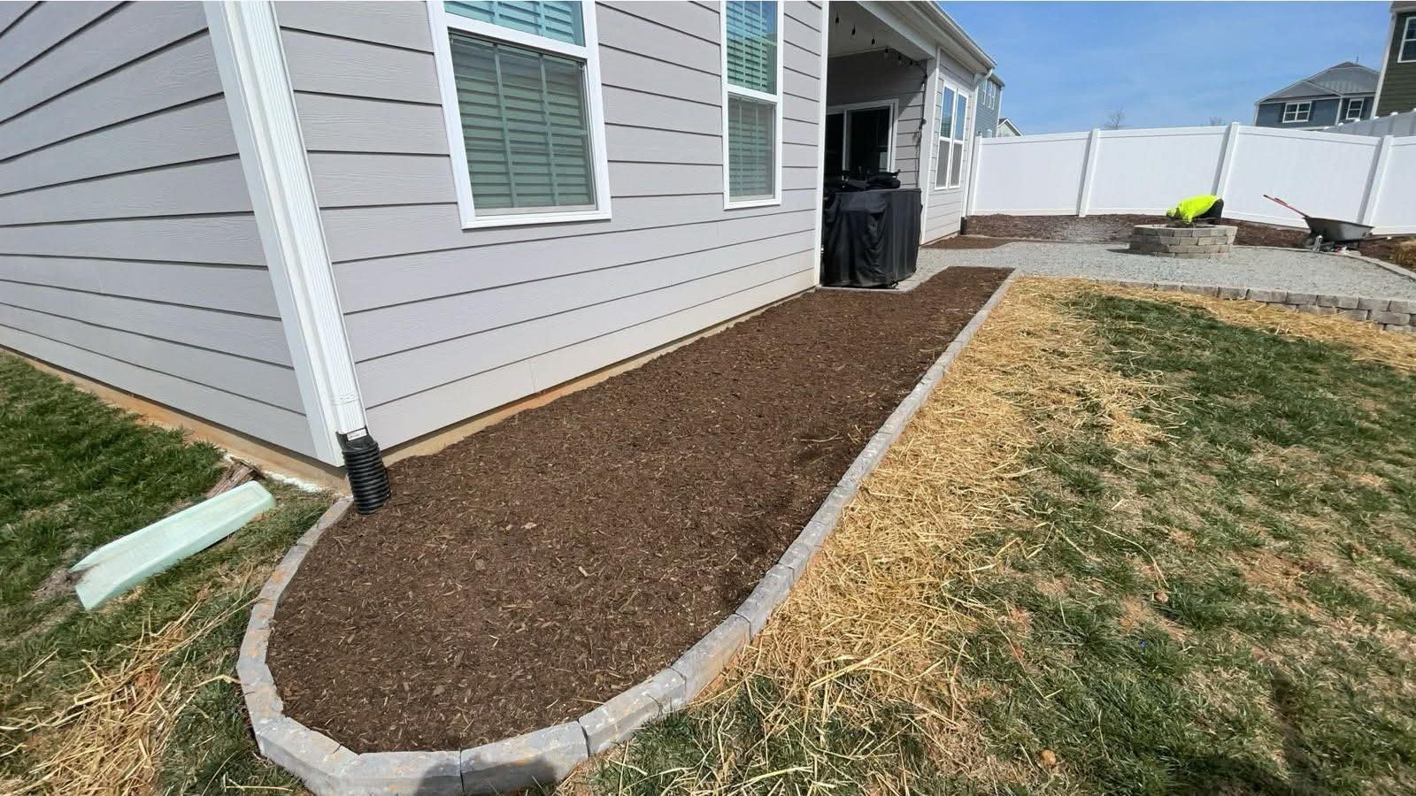 Edged mulch bed along the side of a home