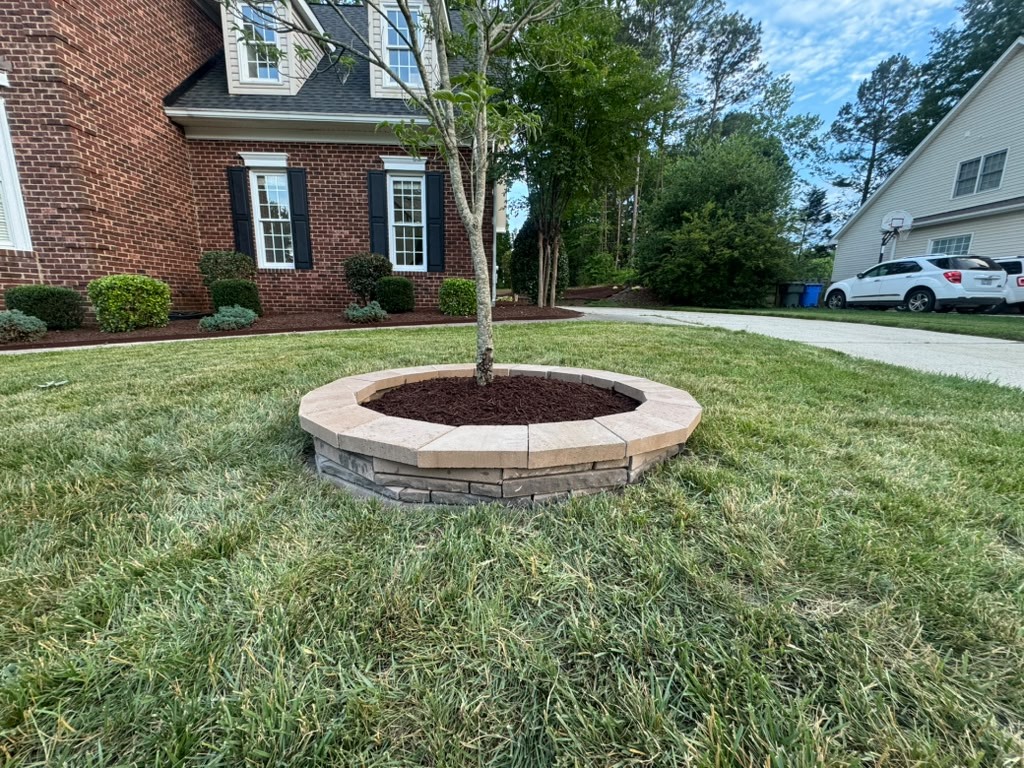 Raised circular stone tree ring at a brick home