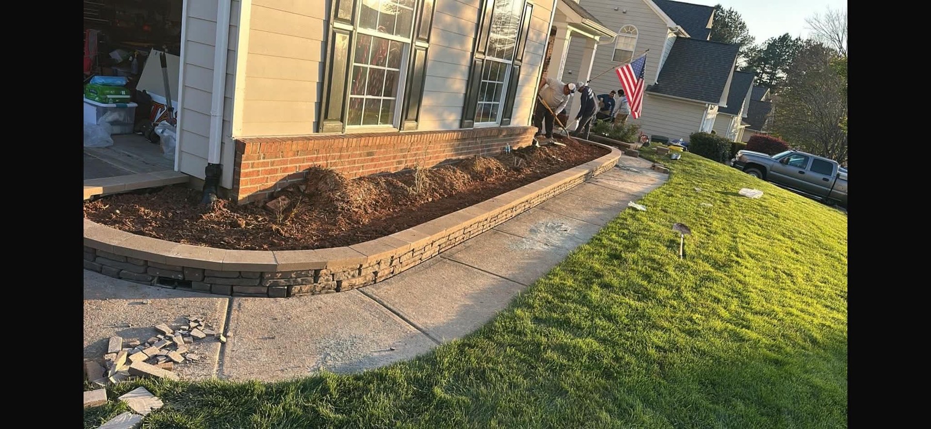 Curved stone planting border beside a front walkway