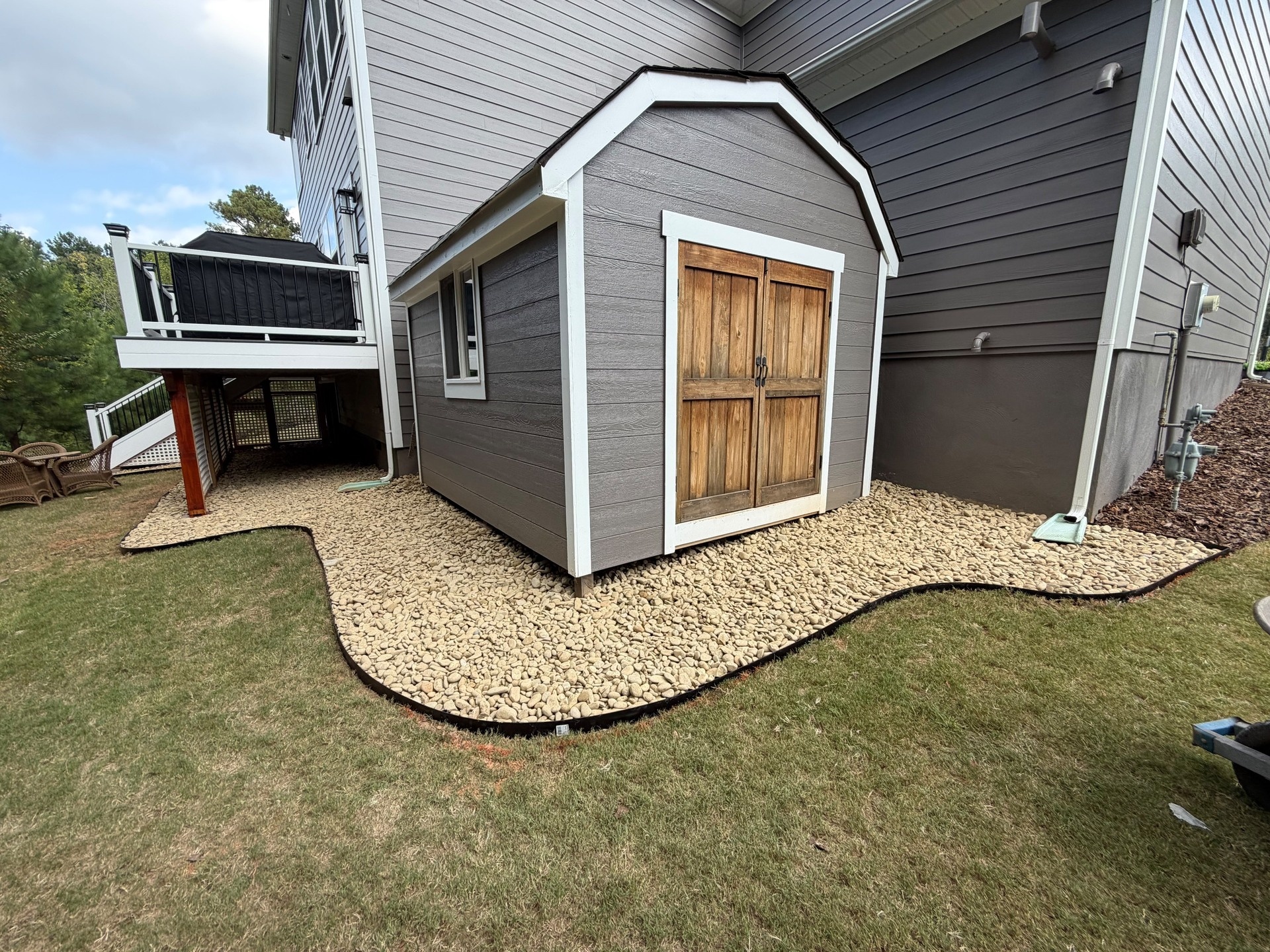 Stone-edged gravel strip around a backyard garden shed