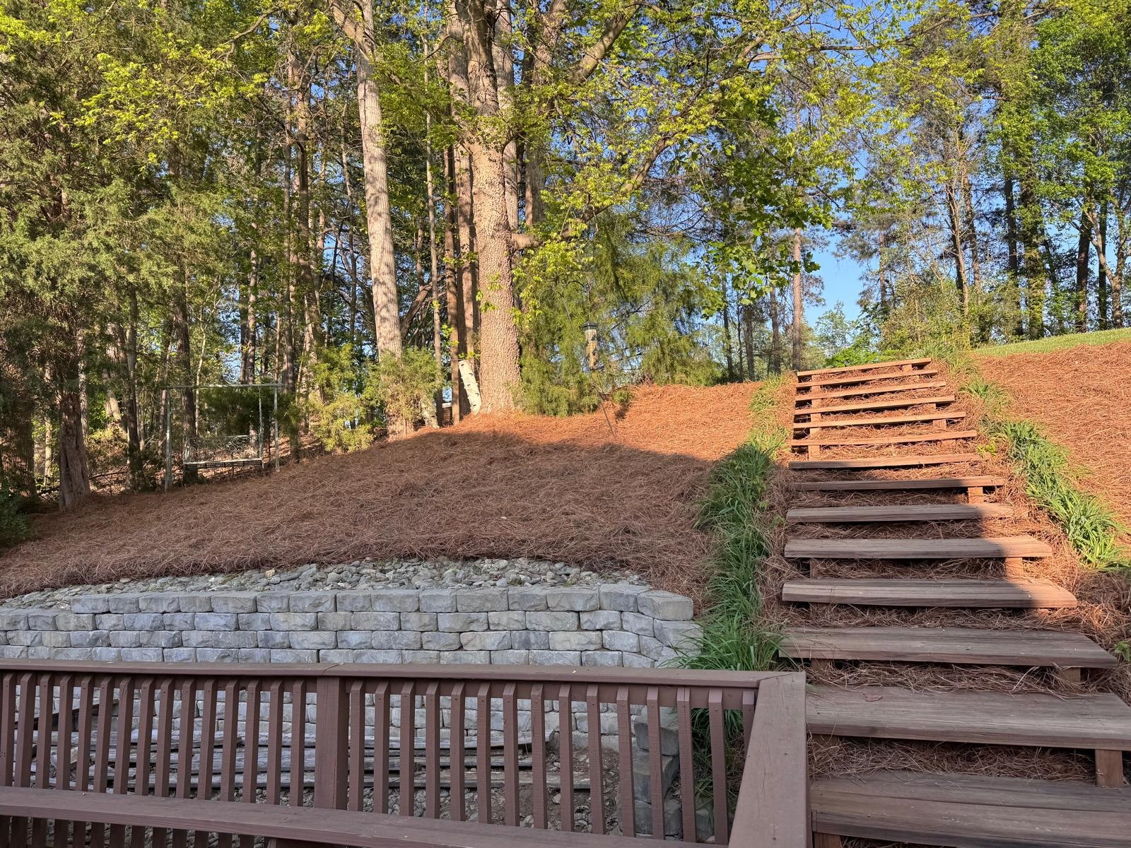 Mulched wooded slope beside gravel and timber garden steps