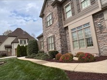 Curved mulched foundation bed with trimmed shrubs at a brick home