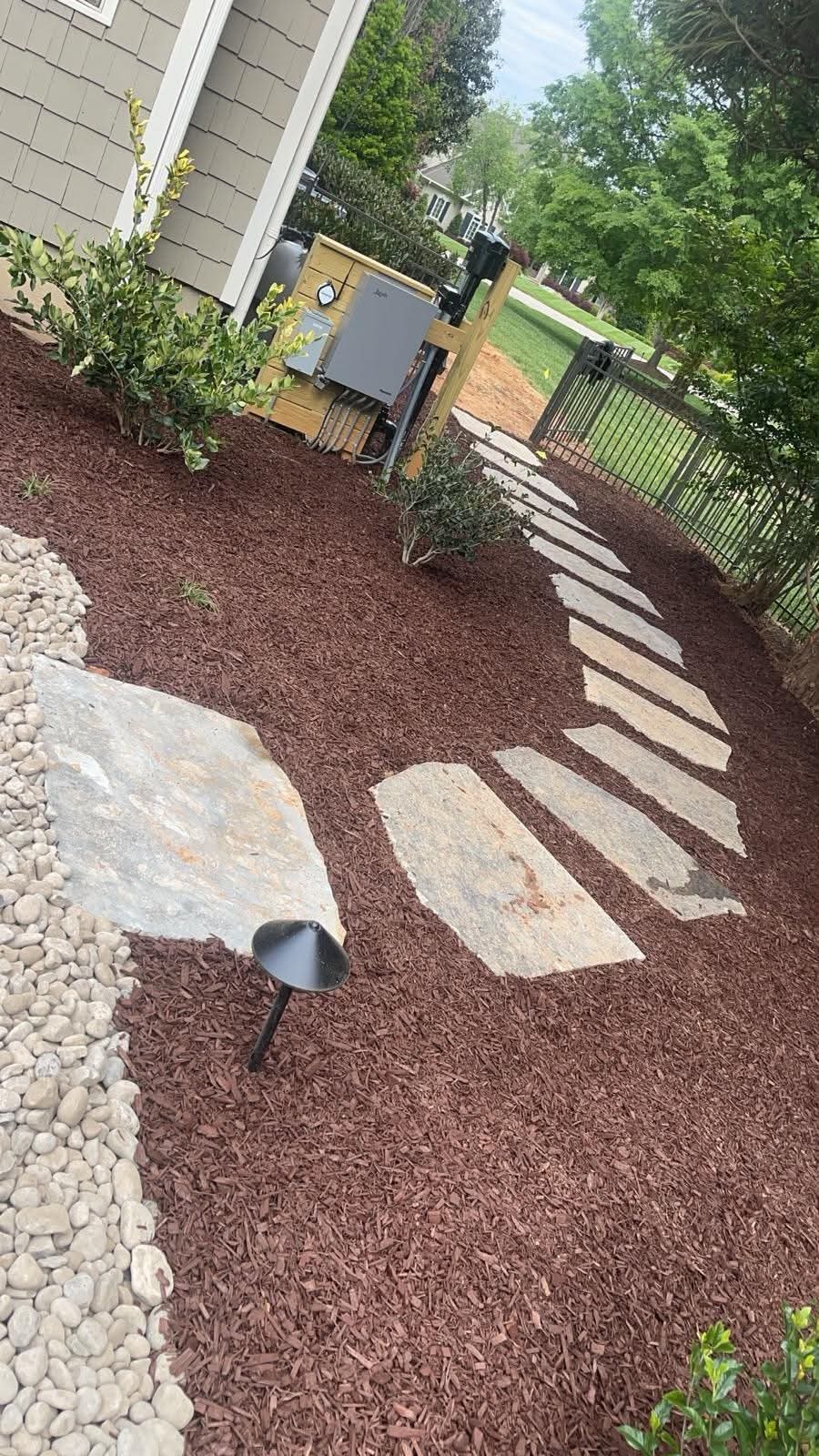 Stepping stone path through a mulched side garden