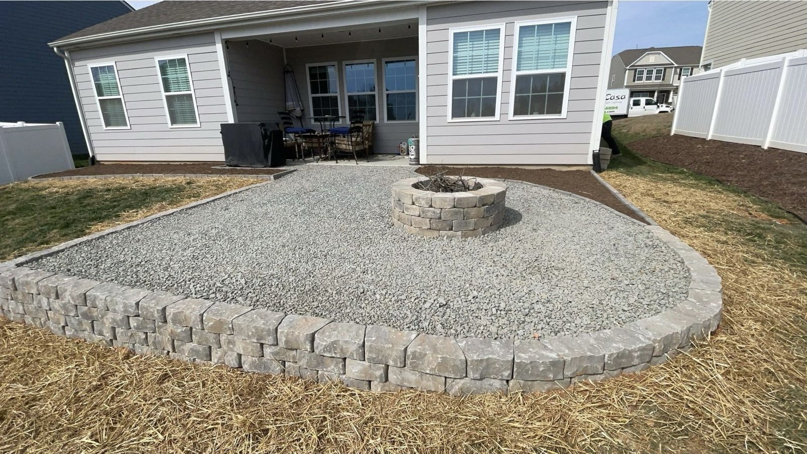 Stone-bordered gravel patio with a circular fire pit