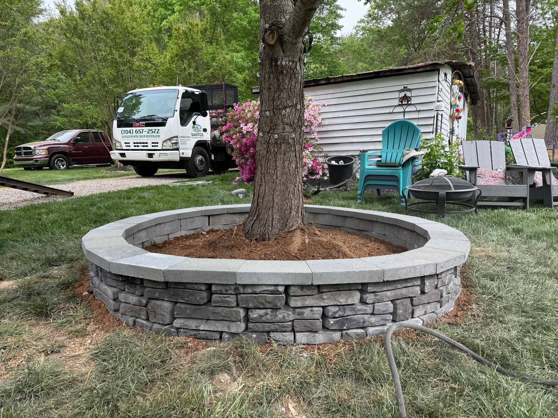 Circular stacked stone border around a mature tree