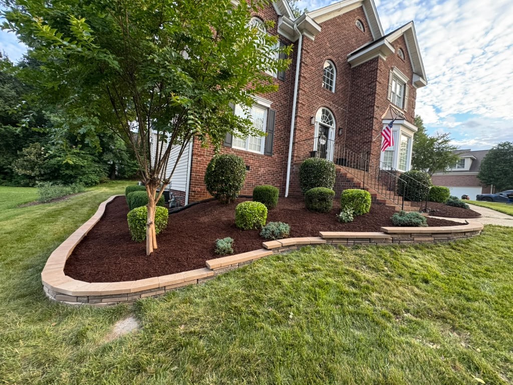 Curved stone borders enclosing front garden beds