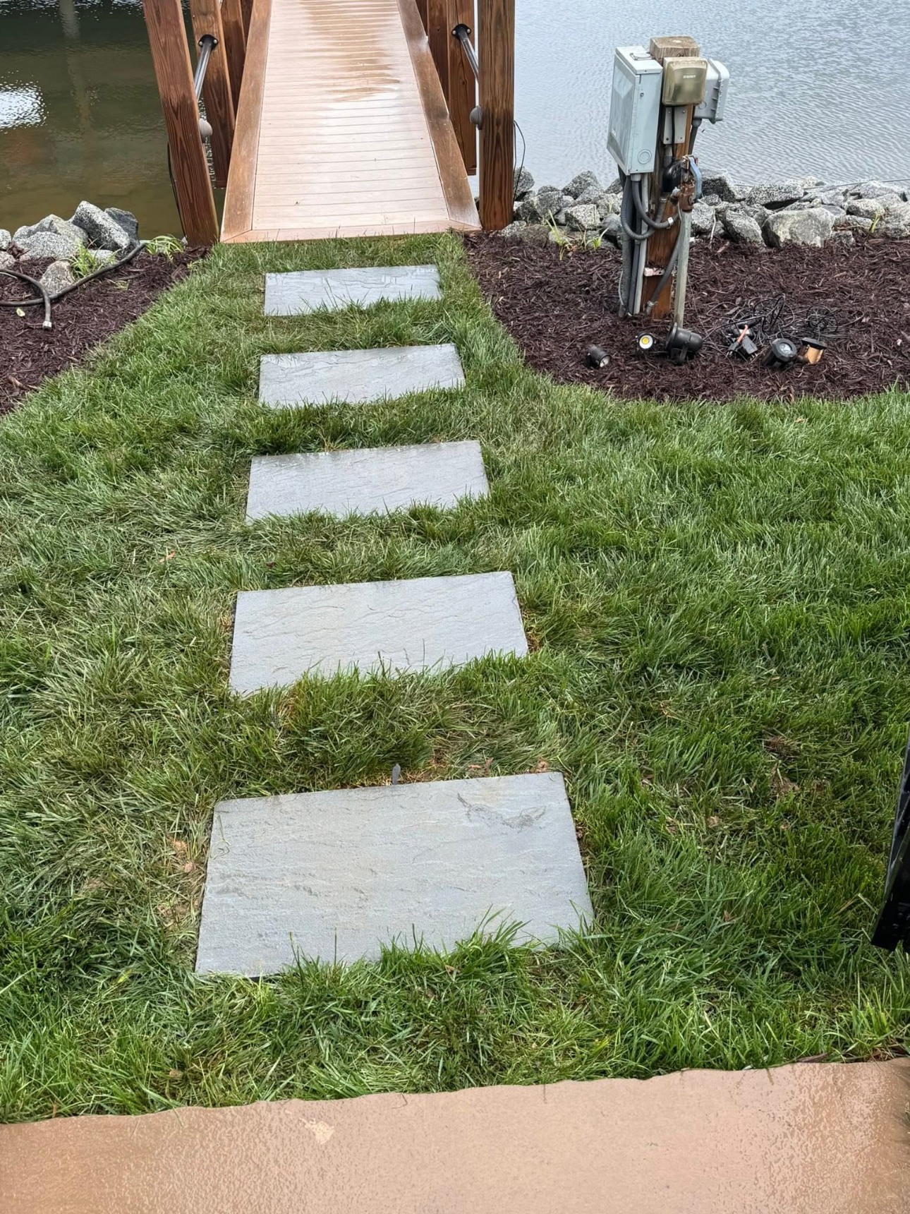 Rectangular stepping stone walkway across a green lawn