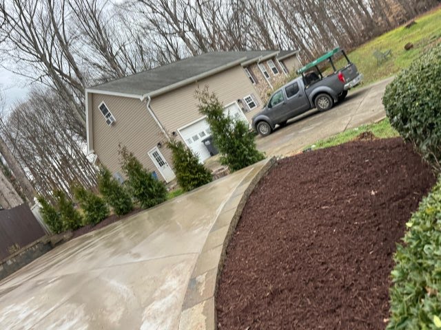 Freshly mulched curved garden bed beside a driveway