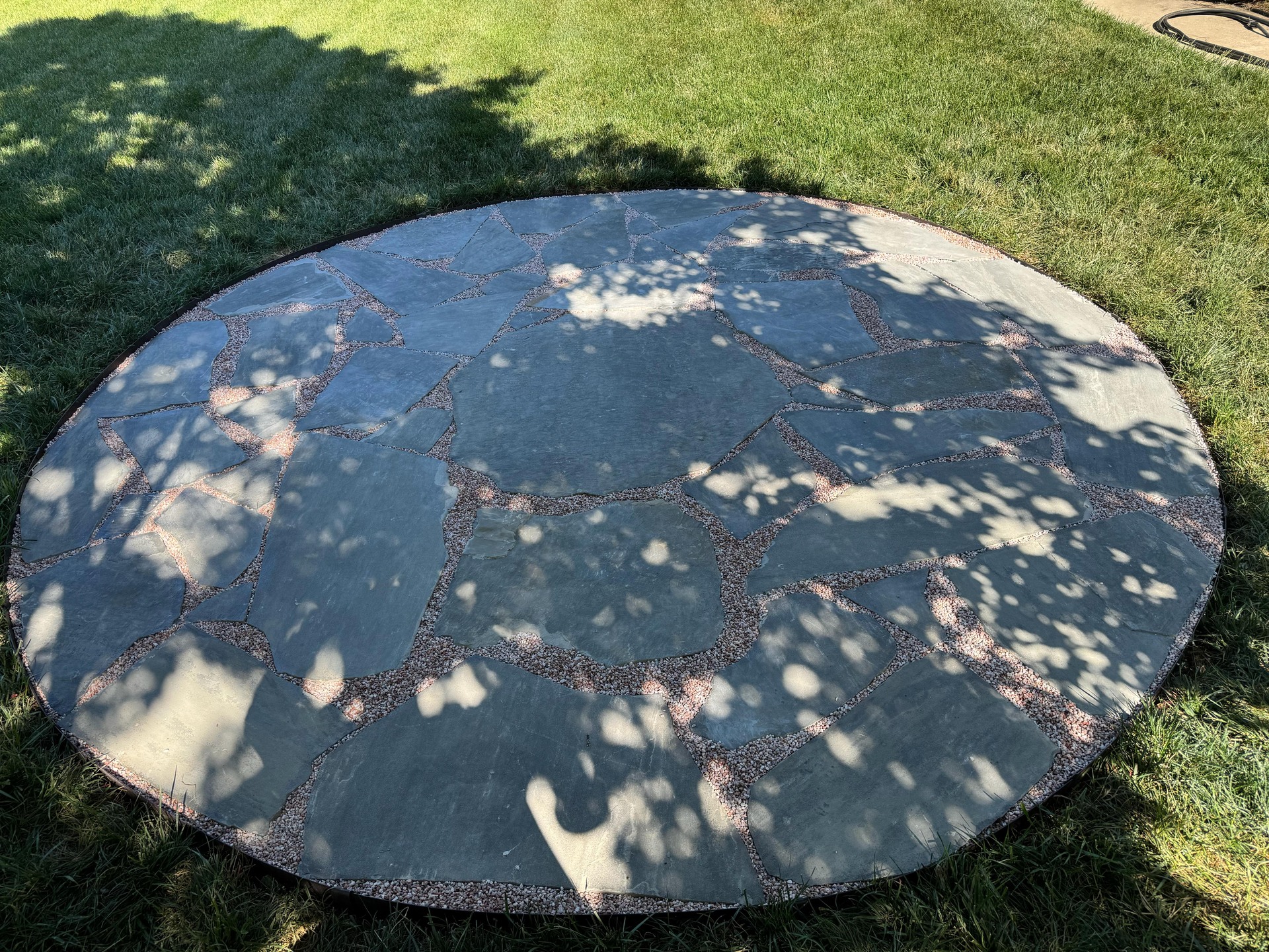 Finished round paved seating area beneath a tree