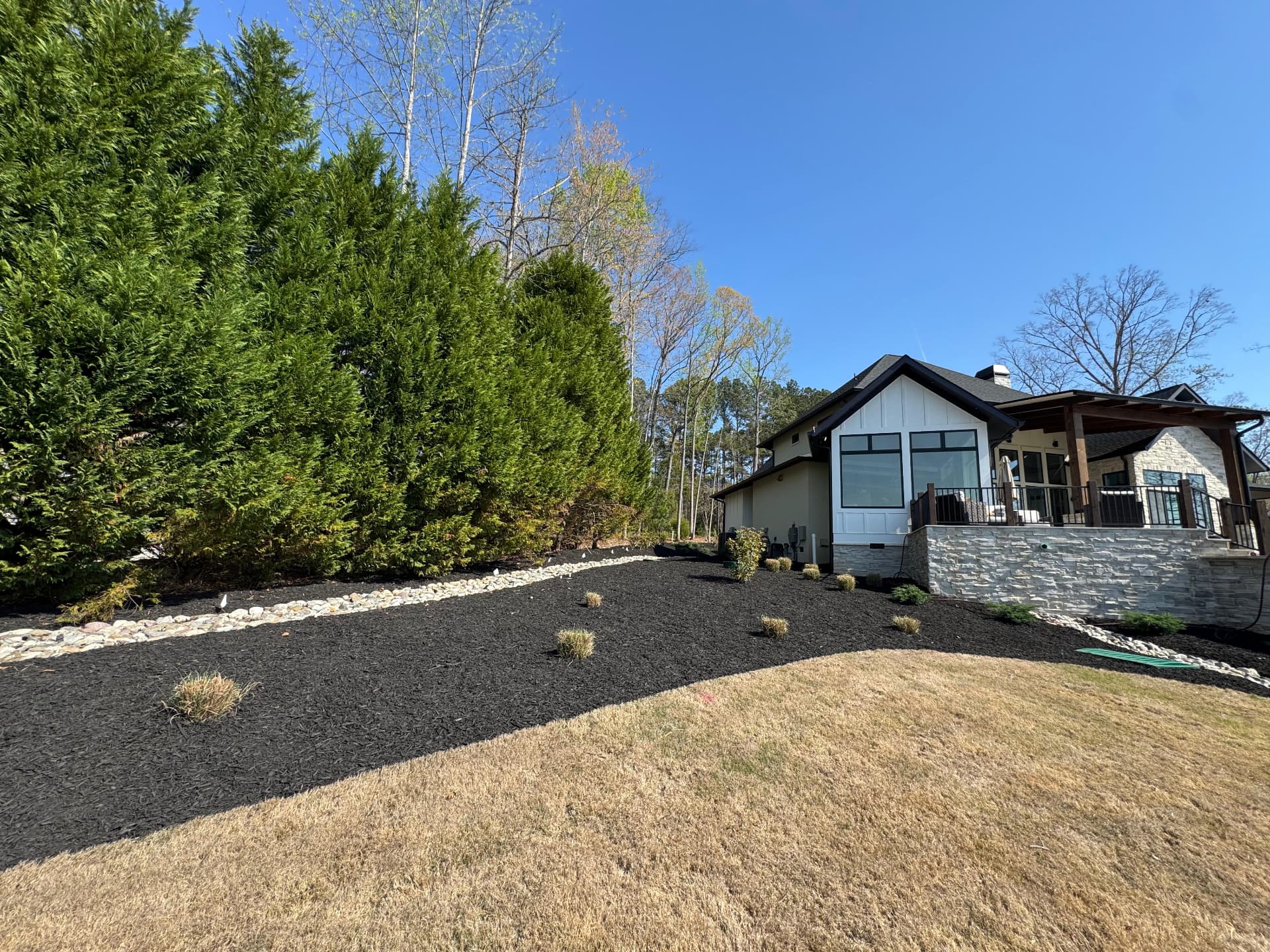 Mulched planting beds along a sloped backyard